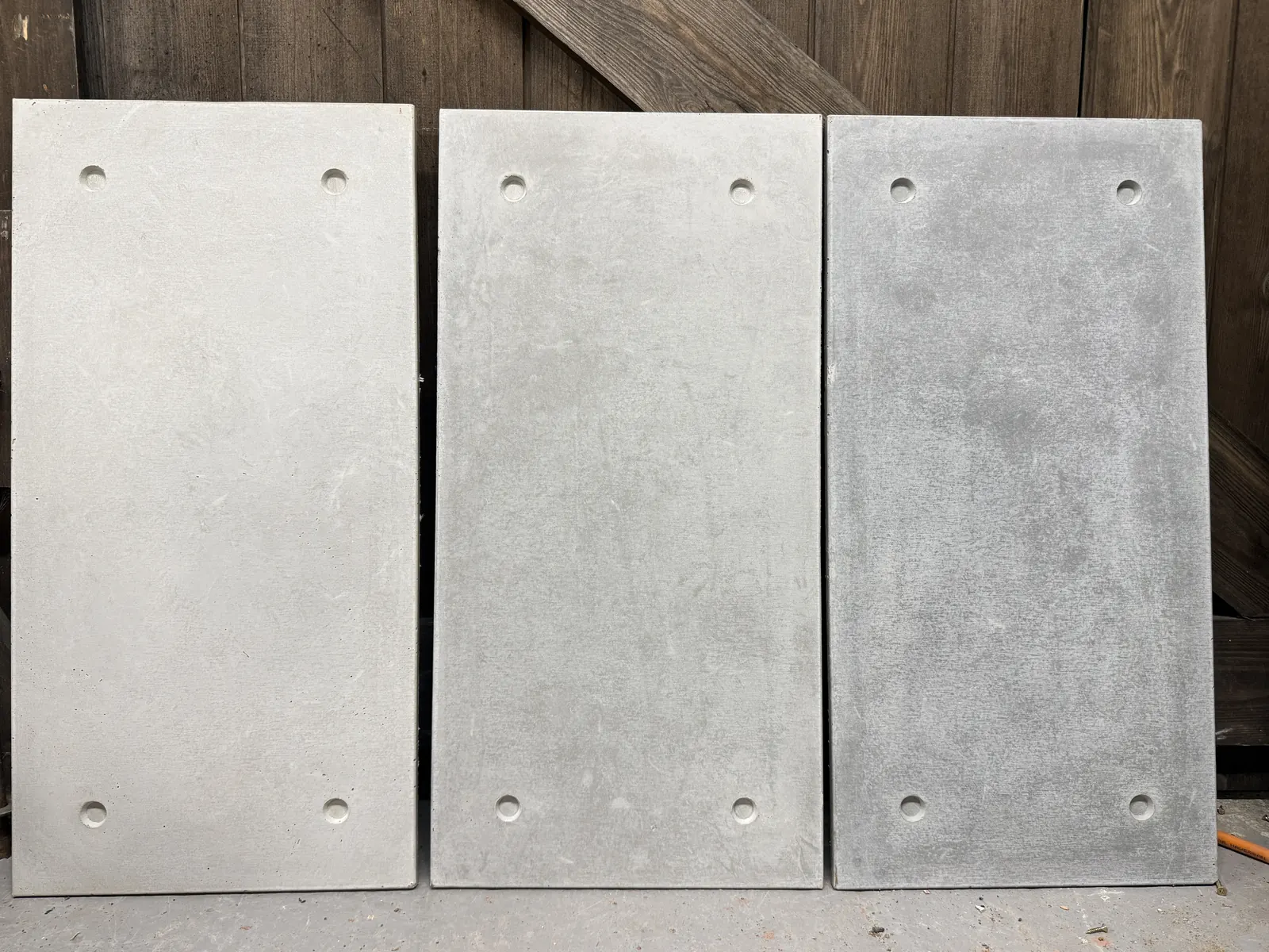 Three cast concrete cladding tiles in pale, mid and dark grey, ROKA Studio