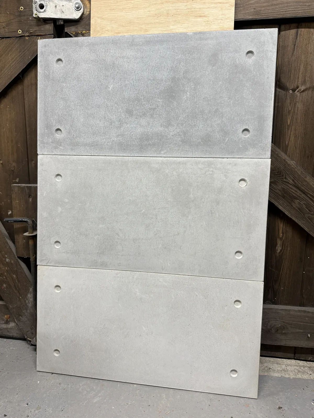 Stack of three cast concrete cladding tiles in graded greys, ROKA Studio
