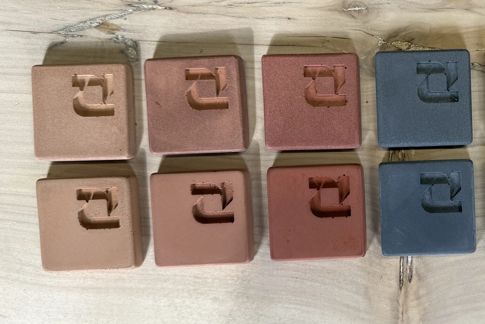 Terracotta, red and charcoal ROKA concrete samples, salt and pepper finish above and cream finish below